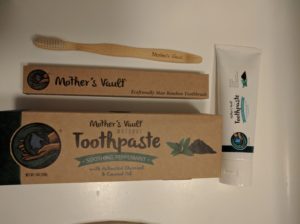 tube of toothpaste and box, bamboo toothbrush and box